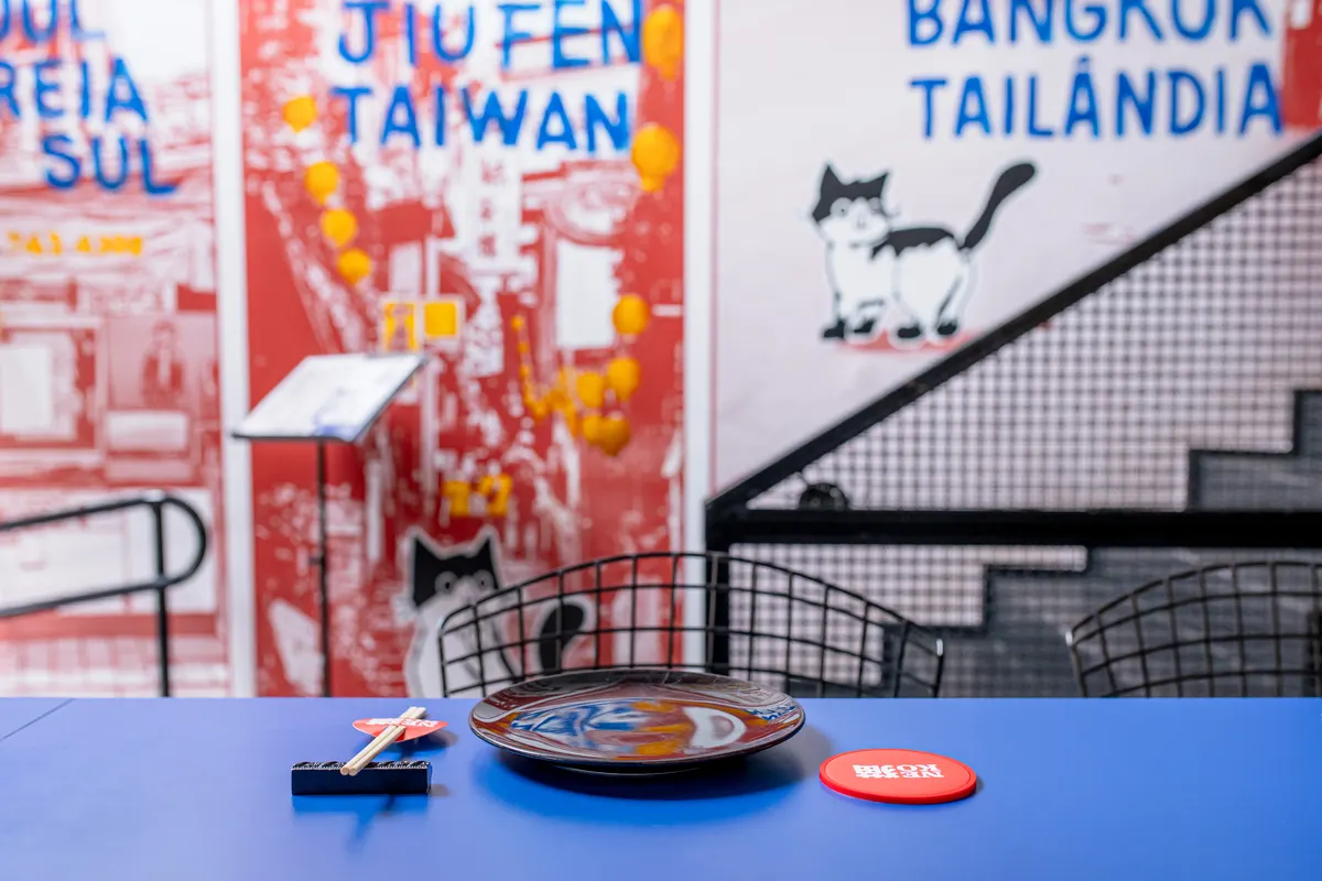 Mesa azul com mural e o gato ao fundo